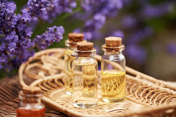 Transparent bottles of aromatherapy essential oil with fresh lavender flowers