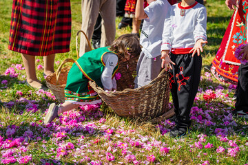 Children dressed in traditional dress with basket of rose petals having fun, playing during Rose...