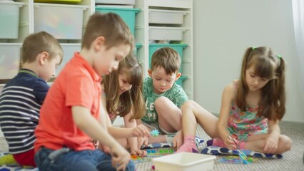 A group of children, like little ants, actively perform speed tasks. The teacher observes their work and smiles at their diligence. High quality 4k footage