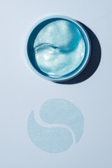 open jar with collagen anti-ageing patches for the eyes and face. Close up, top view