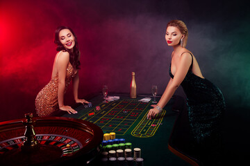 Photo of two luxury ladies play blackjack spins roulette and bluff during opponent not watching...