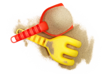 Red plastic shovel and rake in sand, beach toy isolated on white, top view