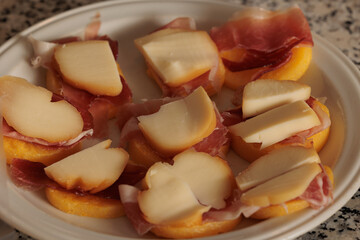 tartine fatte in casa come antipasto a base di fette di polenta, prosciutto crudo e formaggio scamorza