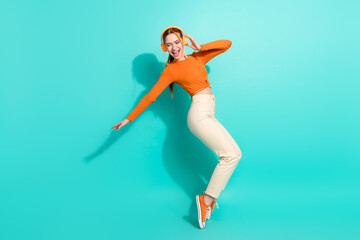 Full length photo of ecstatic woman wear crop top white trousers dancing in headphones on tiptoes...