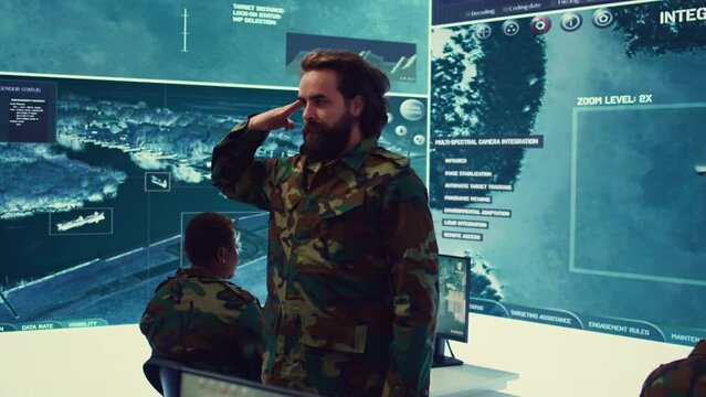 Sergeant presenting his salute with respect for the colonel and high ranking military officers, saluting the captains while he works on intelligence in command center, pride and duty. Camera B.