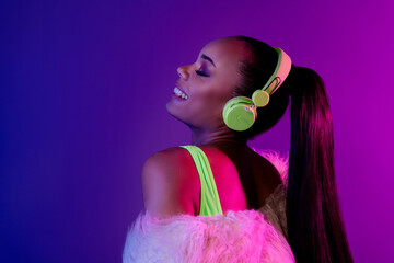 Photo of smiling dreamy lady dressed fur coat earphones enjoy melody emtpy space isolated violet...