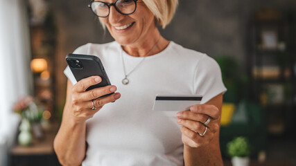 Portrait of senior woman buy online on cellphone with credit card
