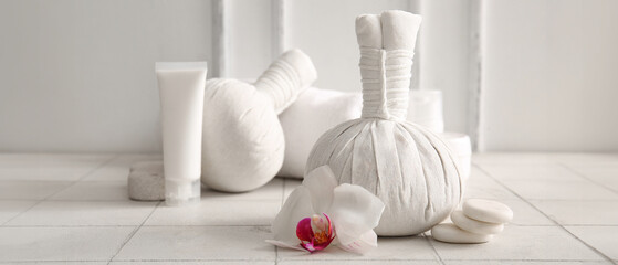 Set of spa accessories and orchid flower on light tile table