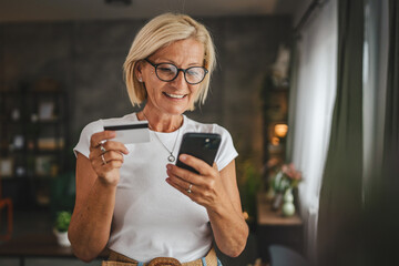 Portrait of senior woman buy online on cellphone with credit card