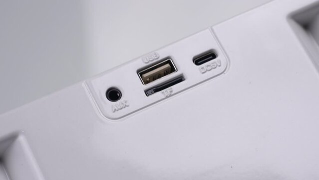 Closeup of white electronic device ports for USB, AUX, DC5V, TF, modern connectivity