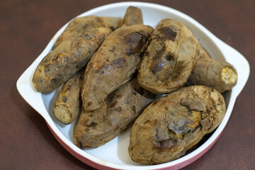 Ubi bakar madu cilembu or Cilembu honey roasted sweet potato on a serving in white plate. it tastes good, sweet honey and soft, traditional food Indonesia.