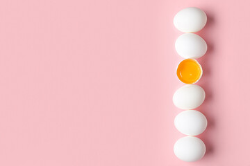 Raw chicken eggs on pink background