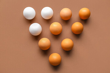 Raw chicken eggs on brown background