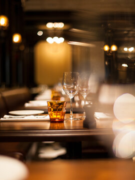 Table setting at a fancy restaurant with moody lighting.