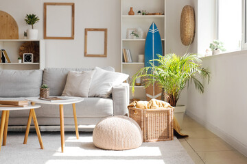 Pouf, basket with plaid and houseplant in living room