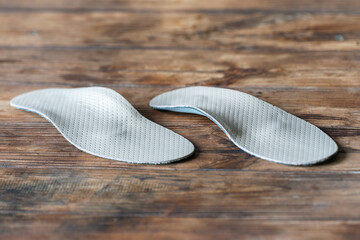 Orthopedic insoles for shoes on a wooden background