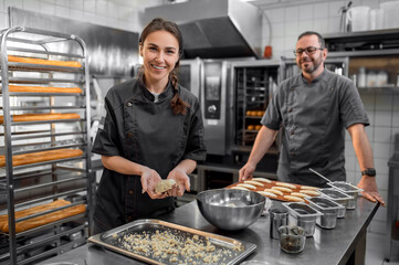 Professional bakers preparing fresh baguette in small bakery