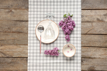 Beautiful table setting with lilac flowers on wooden background