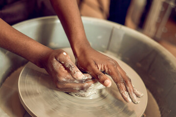 Close up of hands on a pottery wheel