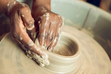 Close up of hands on a pottery wheel
