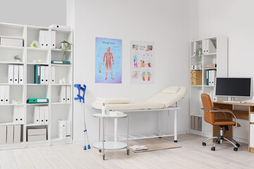 Interior of medical office with massage therapist's workplace and couch