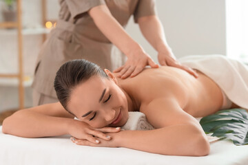 Obraz premium Beautiful young woman getting back massage in spa salon, closeup
