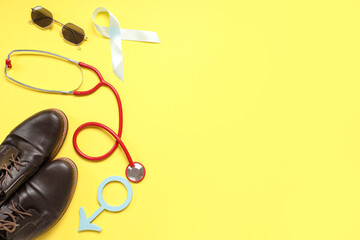 Shoes, stethoscope, tie, male sign and light blue ribbon on yellow background. Prostate cancer...