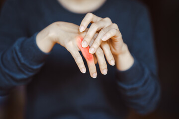 Close-up of a person massaging their fingers, highlighting pain and joint discomfort, possibly...