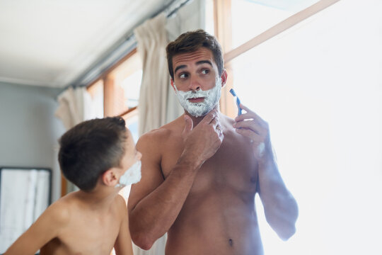 Bathroom, bonding and father shaving with kid for hygiene, grooming and health routine. Teaching, child development and boy learning razor facial epilation treatment with dad for skincare at home.