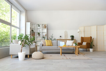 Interior of modern living room with sofas, table and big window