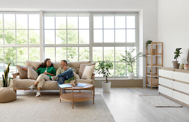 Young couple chatting on sofa at home
