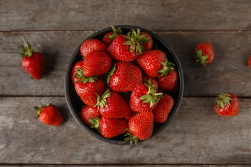 Bowl with sweet fresh strawberries on wooden background