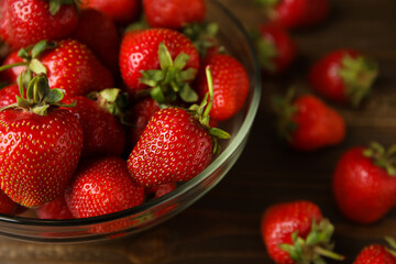 Glass bowl with sweet fresh strawberries on wooden background