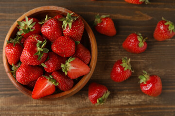 Bowl with sweet fresh strawberries on wooden background