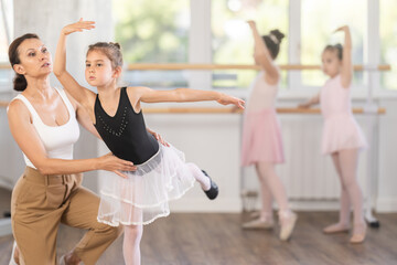 Ballet lesson for little girls - choreography teacher shows little ballerinas how to get into...