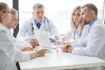Doctors meeting at a large white table