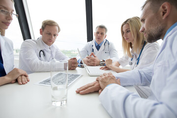 Doctors meeting at a large white table