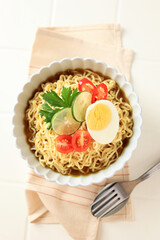Indomie Rebus or Instant Boiled Noodle on Ceramic Bowl