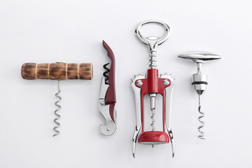 Different corkscrews on white background, flat lay