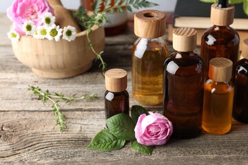 Aromatherapy. Different essential oils and flowers on wooden table