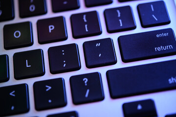 Close-up of Modern Black Keyboard with Glowing Blue Backlight, Focus on Enter Key