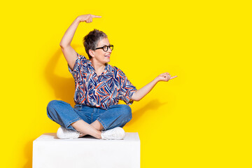 Full body photo of attractive retired woman sit cube point empty space dressed stylish colorful...