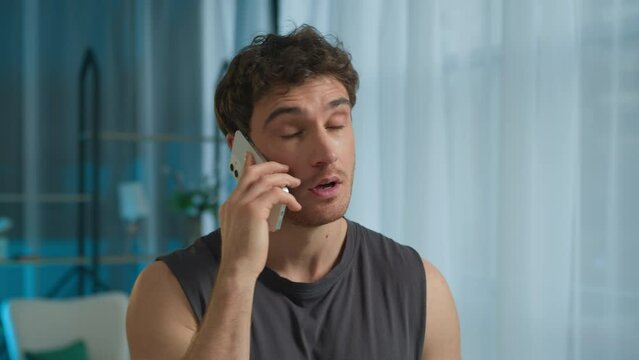 Caucasian man athlete talking mobile phone smartphone call sport guy male sportsman technology telephone anger annoyed frowning unhappy dissatisfied displeased home training problem communicate gadget