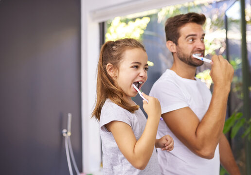 House, brushing teeth and father with girl, cleaning mouth and morning routine with grooming. Family, dad and daughter with fresh breath, dental hygiene and oral care with dental wellness and playful - Powered by Adobe