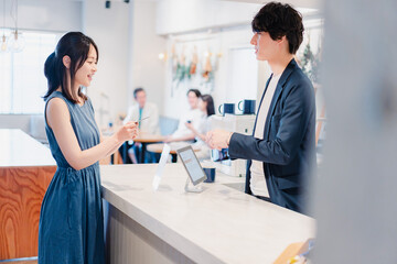 Obraz premium レジでクレジットカード決済をする若い女性