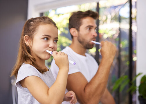 Bathroom, brushing teeth and father with girl, morning routine and grooming with dental hygiene. Family, dad or daughter with fresh breath, cleaning mouth or oral care with wellness, home or playful - Powered by Adobe