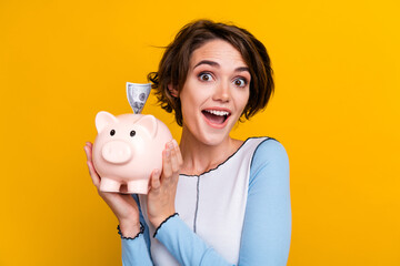 Photo of charming excited woman wear top collecting cash money box isolated yellow color background