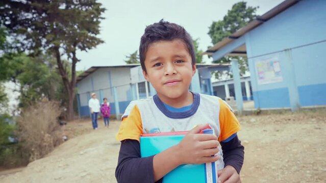 Portrait of a student boy in front of a public education building.