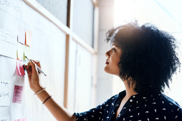 Woman, creative and office with whiteboard or sticky notes, planning and writing with pen for...