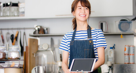 客を迎える女性カフェスタッフ